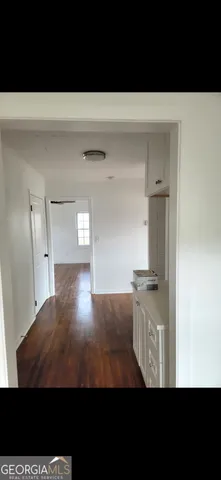 a view of kitchen and hallway with wooden floor