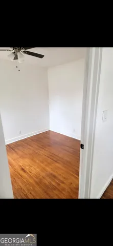 a view of empty room with wooden floor