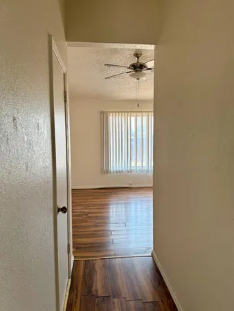 a view of a hallway with wooden floor and staircase