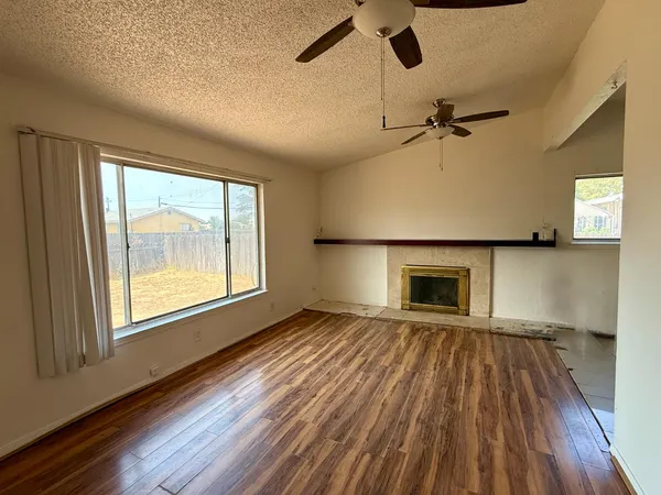 wooden floor fireplace and windows in an empty room