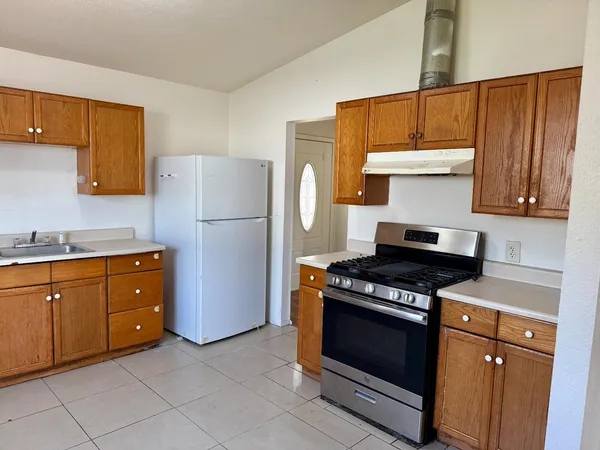 a kitchen with granite countertop a stove and a refrigerator