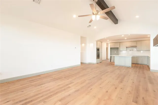 a large white kitchen with kitchen island a sink stainless steel appliances and cabinets