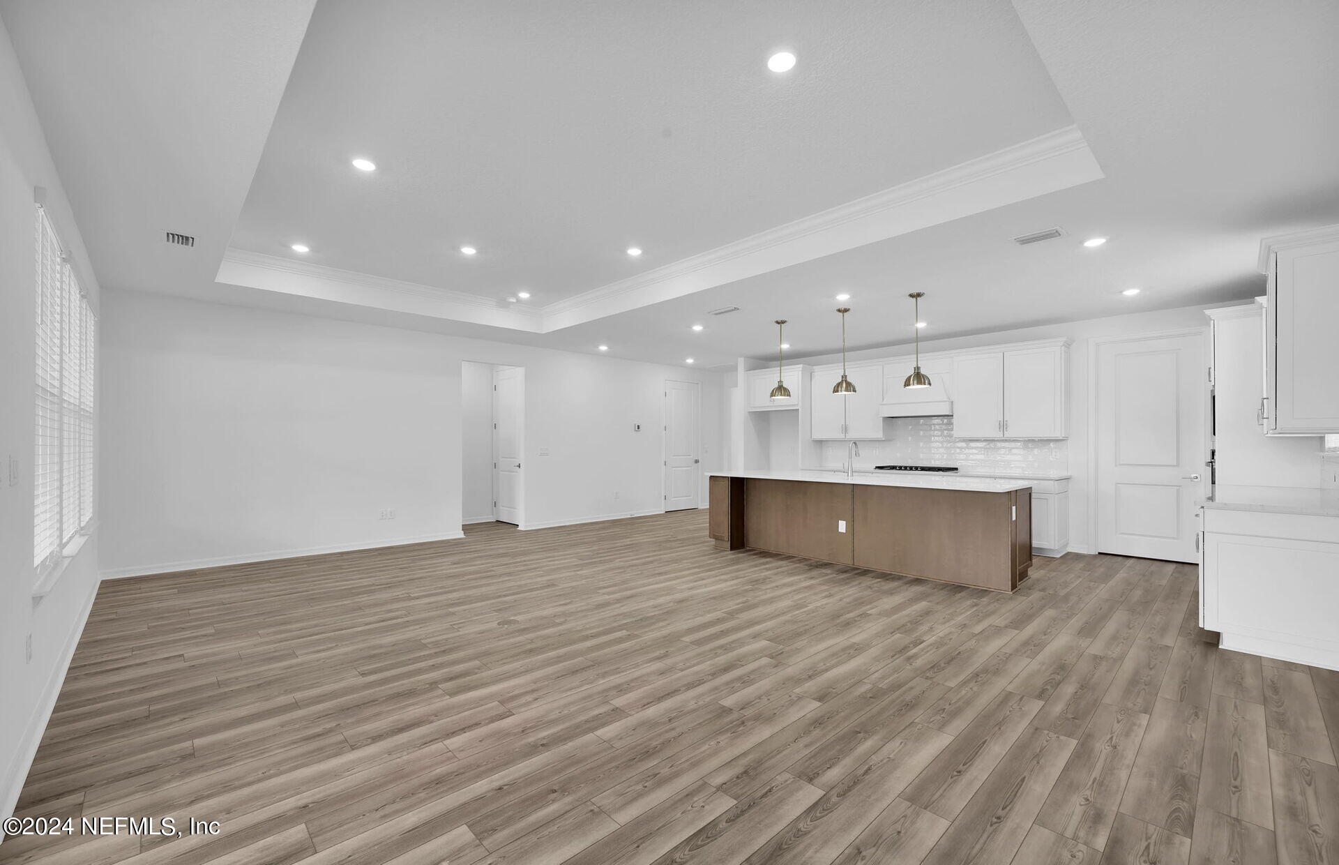 236 Hickory Pine Drive St. Augustine, FL 32092 - Photo 16 of 46 a large white kitchen with kitchen island a sink wooden floor and a refrigerator