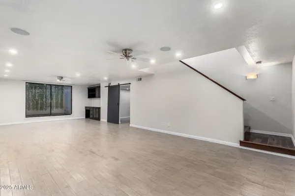 an empty room with cabinet and windows