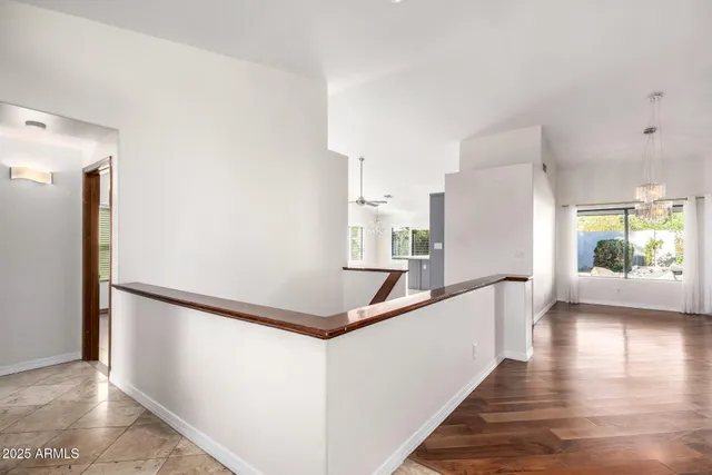 a view of a hallway with wooden floor and staircase