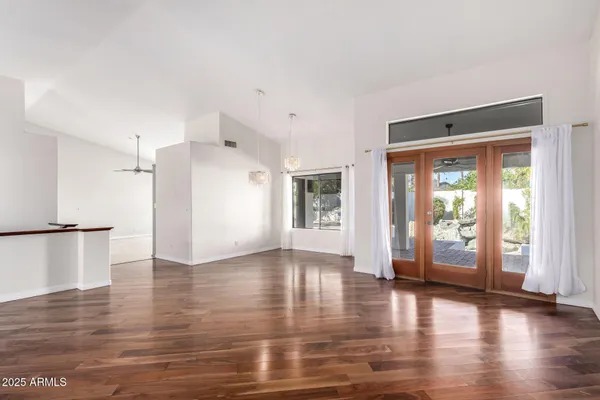 a view of an empty room with window and wooden floor