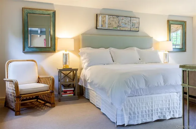 a view of a house that has a small yard plants and large trees