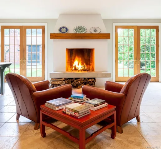 a living room with furniture a large window and a fireplace