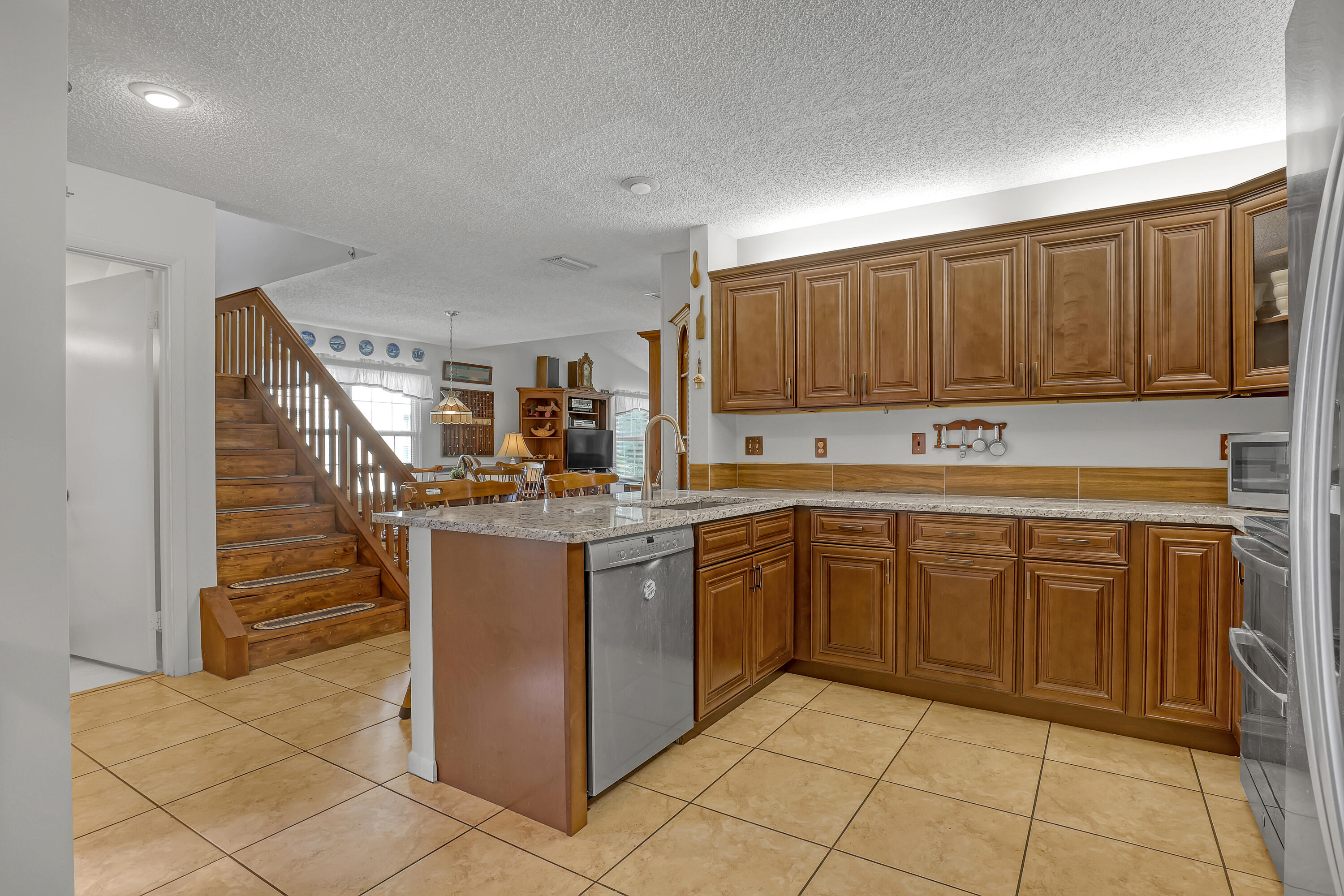13116 Quiet Woods Road, Unit A Wellington, FL 33414 - Photo 11 of 31 a kitchen with stainless steel appliances granite countertop a refrigerator and a sink
