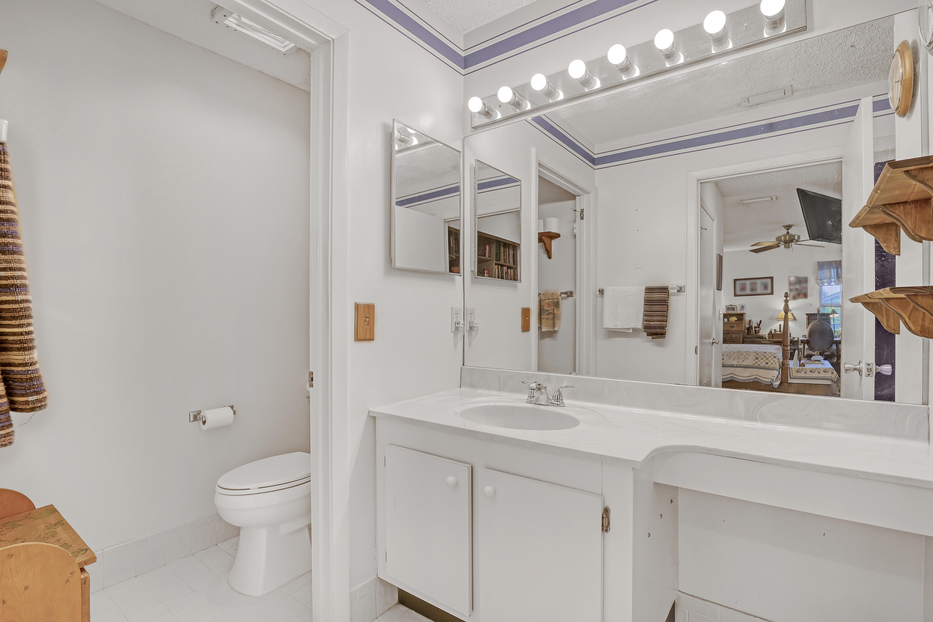 13116 Quiet Woods Road, Unit A Wellington, FL 33414 - Photo 21 of 31 a bathroom with a toilet sink and mirror