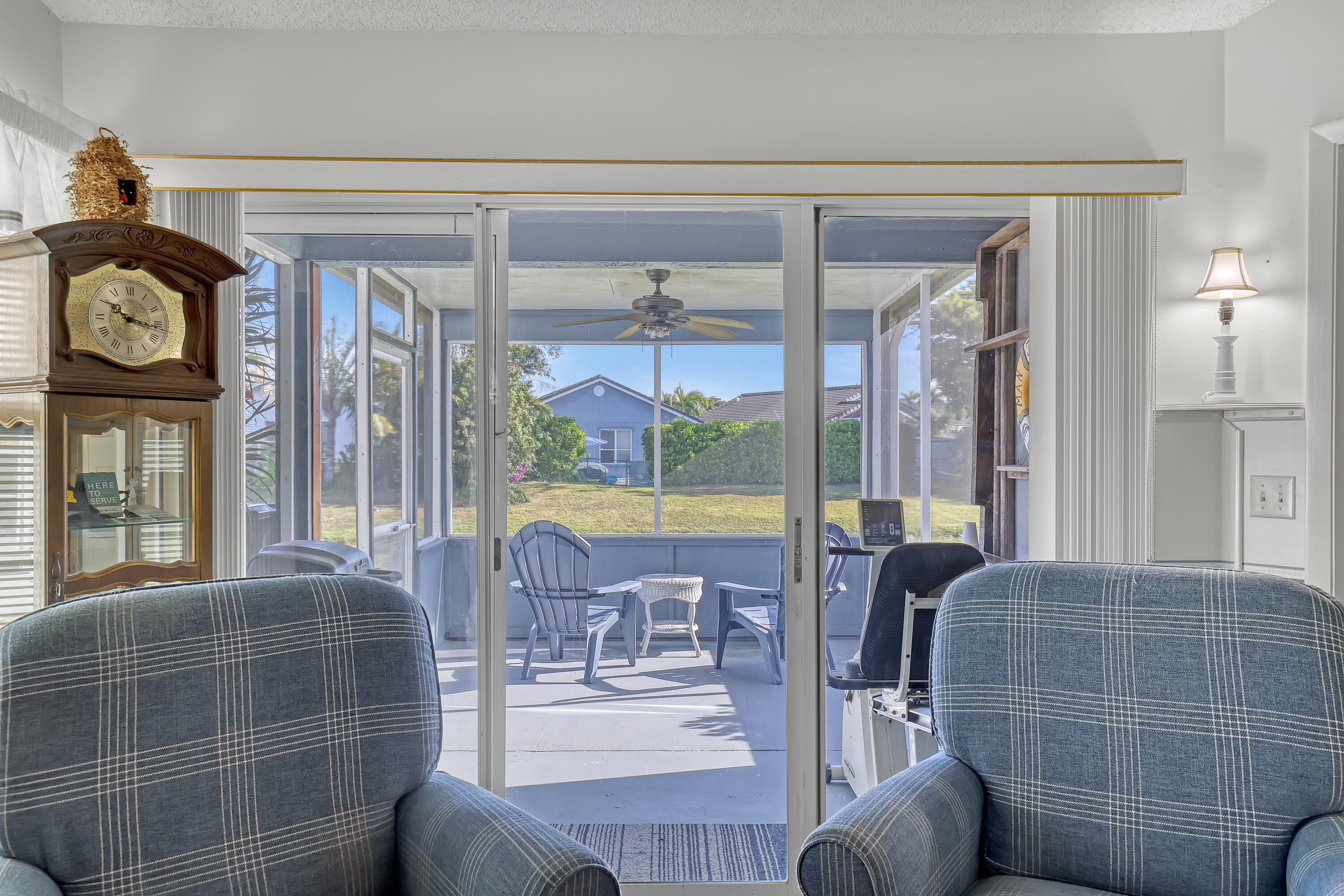 13116 Quiet Woods Road, Unit A Wellington, FL 33414 - Photo 9 of 31 a living room with furniture a flat screen tv and floor to ceiling windows