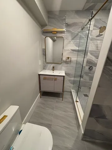 a bathroom with a sink a toilet and mirror