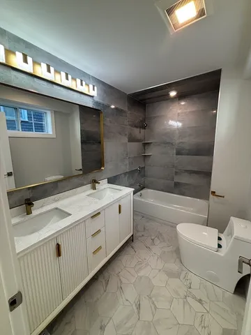 a bathroom with a double vanity sink a mirror and a bathtub