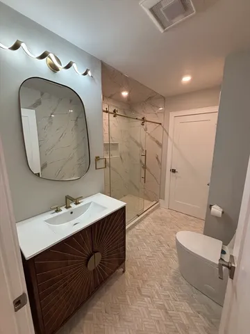 a bathroom with a sink a toilet and shower