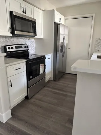 a kitchen with stainless steel appliances a refrigerator microwave and sink