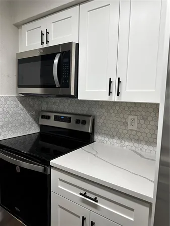 a close view of a stove a microwave and cabinets