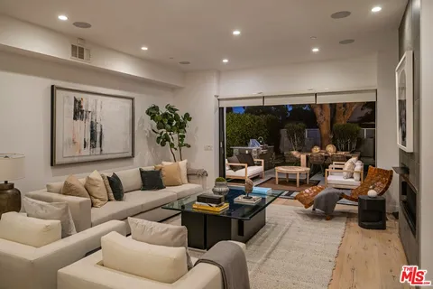 a dining room with furniture a rug and kitchen view