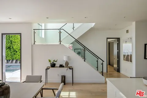 a view of a hallway with wooden floor and a living room