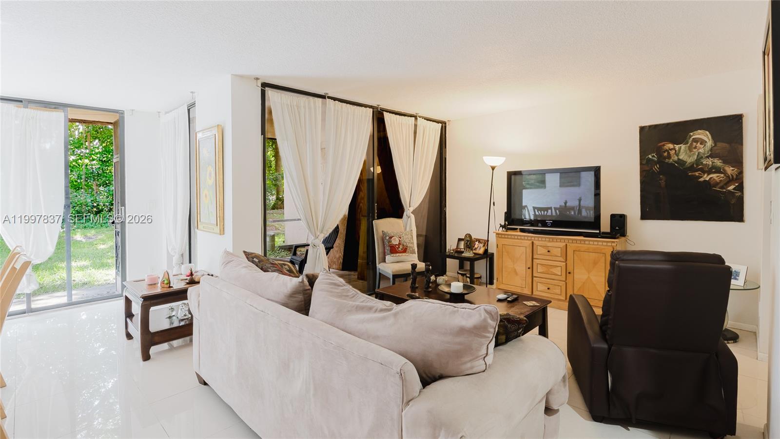 101 Southwest 96th Terrace, Unit 101 Plantation, FL 33324 - Photo 14 of 37 a living room with furniture and a flat screen tv with wooden floor
