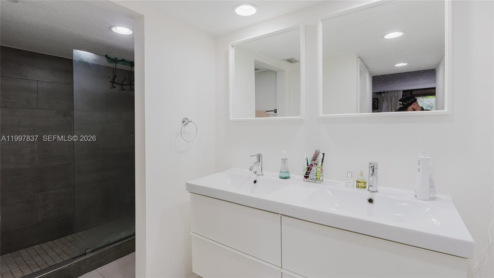 101 Southwest 96th Terrace, Unit 101 Plantation, FL 33324 - Photo 20 of 37 a bathroom with a sink a mirror and shower
