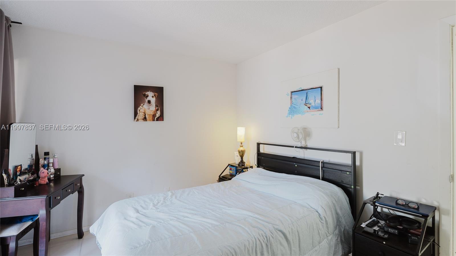 101 Southwest 96th Terrace, Unit 101 Plantation, FL 33324 - Photo 24 of 37 a bedroom with a bed and a lamp on the dresser