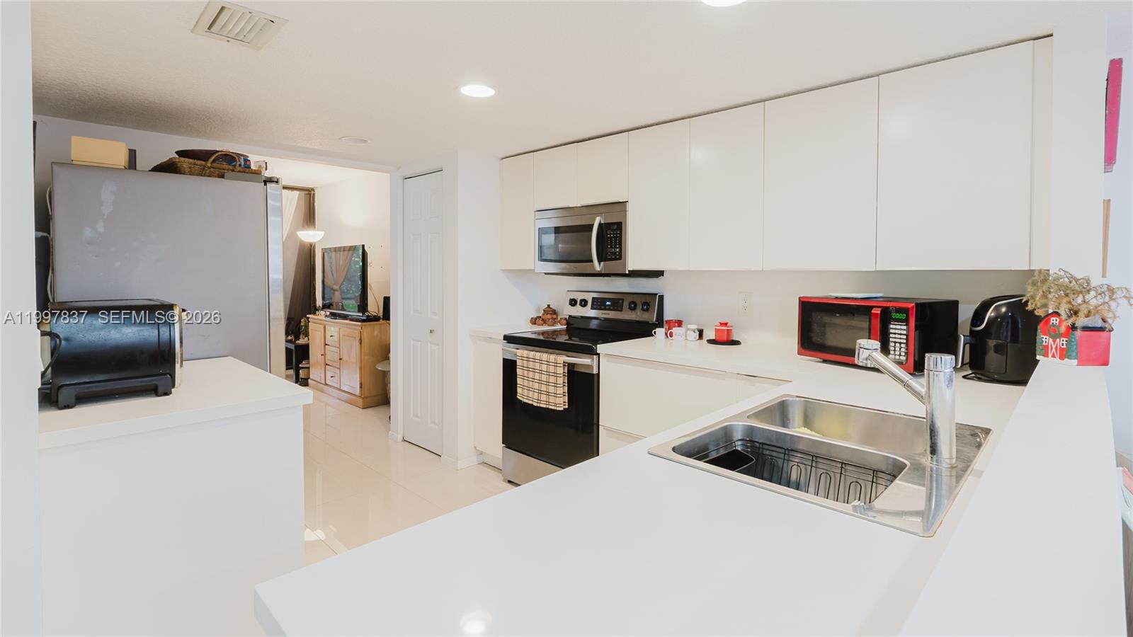 101 Southwest 96th Terrace, Unit 101 Plantation, FL 33324 - Photo 8 of 37 a kitchen that has a sink and a stove top oven