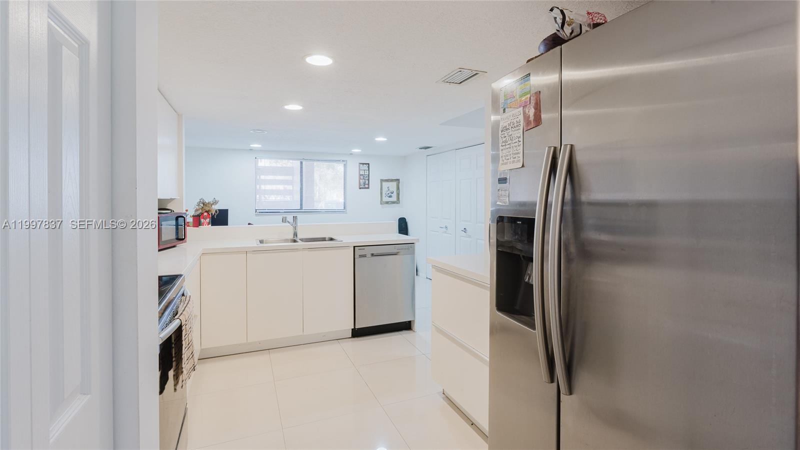 101 Southwest 96th Terrace, Unit 101 Plantation, FL 33324 - Photo 10 of 37 a kitchen with a refrigerator a sink and cabinets
