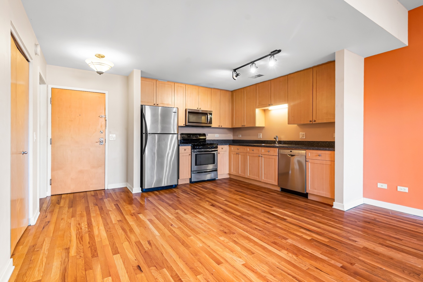 1910 South State Street, Unit 305 Chicago, IL 60616 - Photo 11 of 20 a kitchen with stainless steel appliances granite countertop a refrigerator a sink a stove and oven with wooden floor