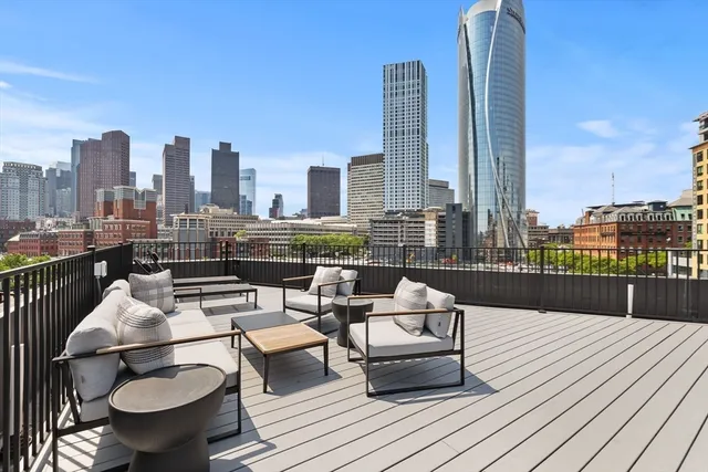 a balcony with wooden floor table and chairs