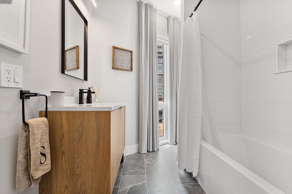 43 Stillman Street, Unit PH Boston, MA 02113 - Photo 12 of 17 a bathroom with a tub sink and mirror