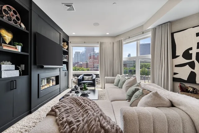 a living room with furniture a fireplace and a flat screen tv