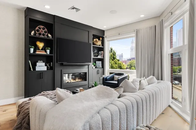 a bedroom with furniture a fireplace and a flat screen tv