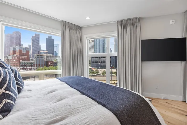 a bedroom with a large bed and a flat tv screen