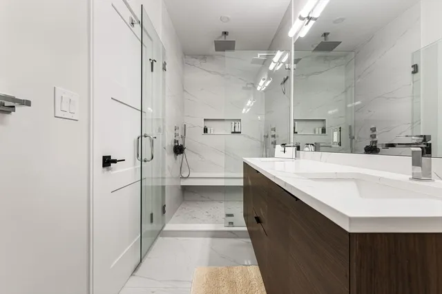 a bathroom with a double vanity sink mirror and shower