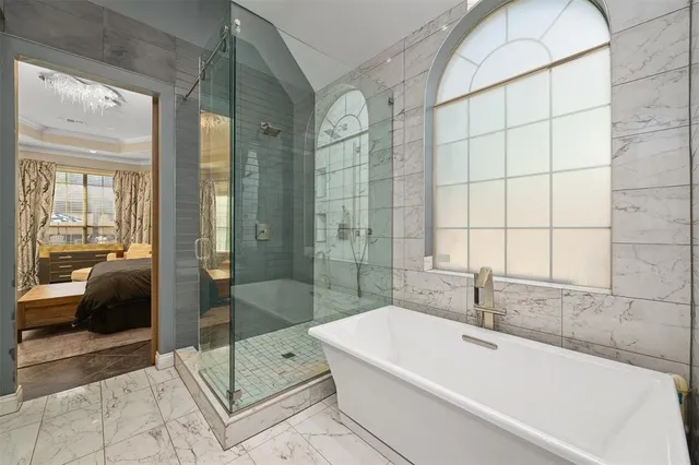 a bathroom with a large tub a shower and view