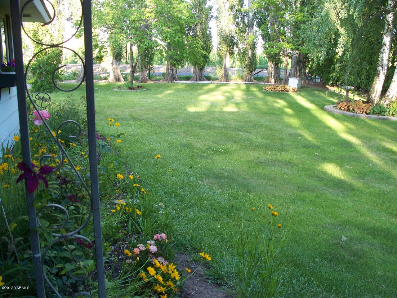 290 Beane Road Moxee, WA 98936 - Photo 14 of 19 a backyard of a house with lots of green space and plants
