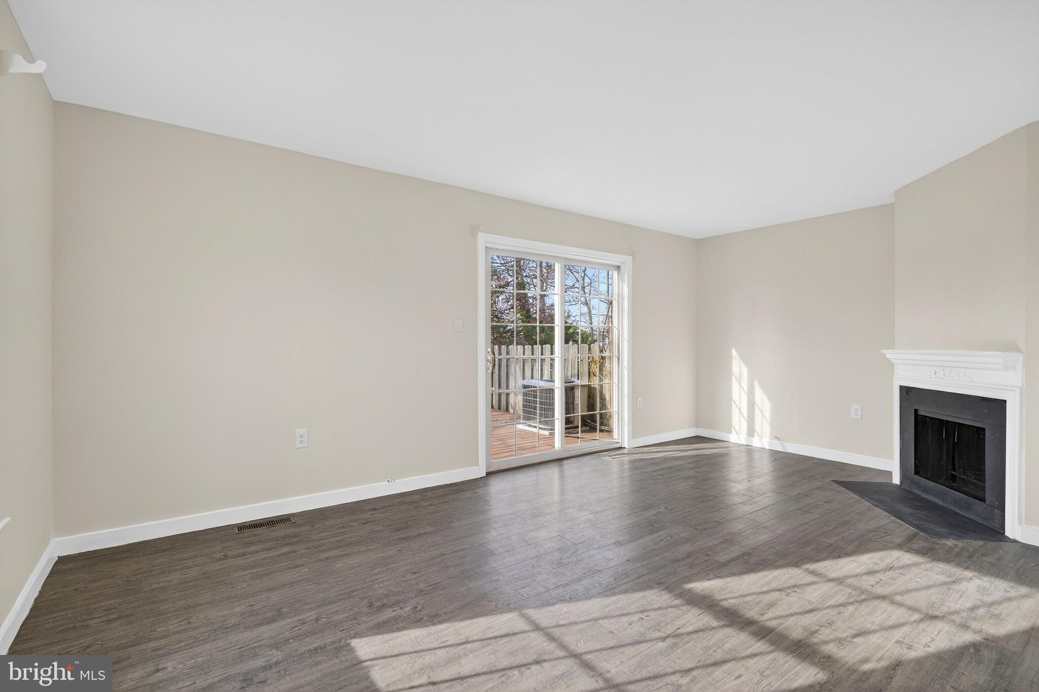 6476 Franconia Court Springfield, VA 22150 - Photo 3 of 41 a view of an empty room with wooden floor fireplace and a window