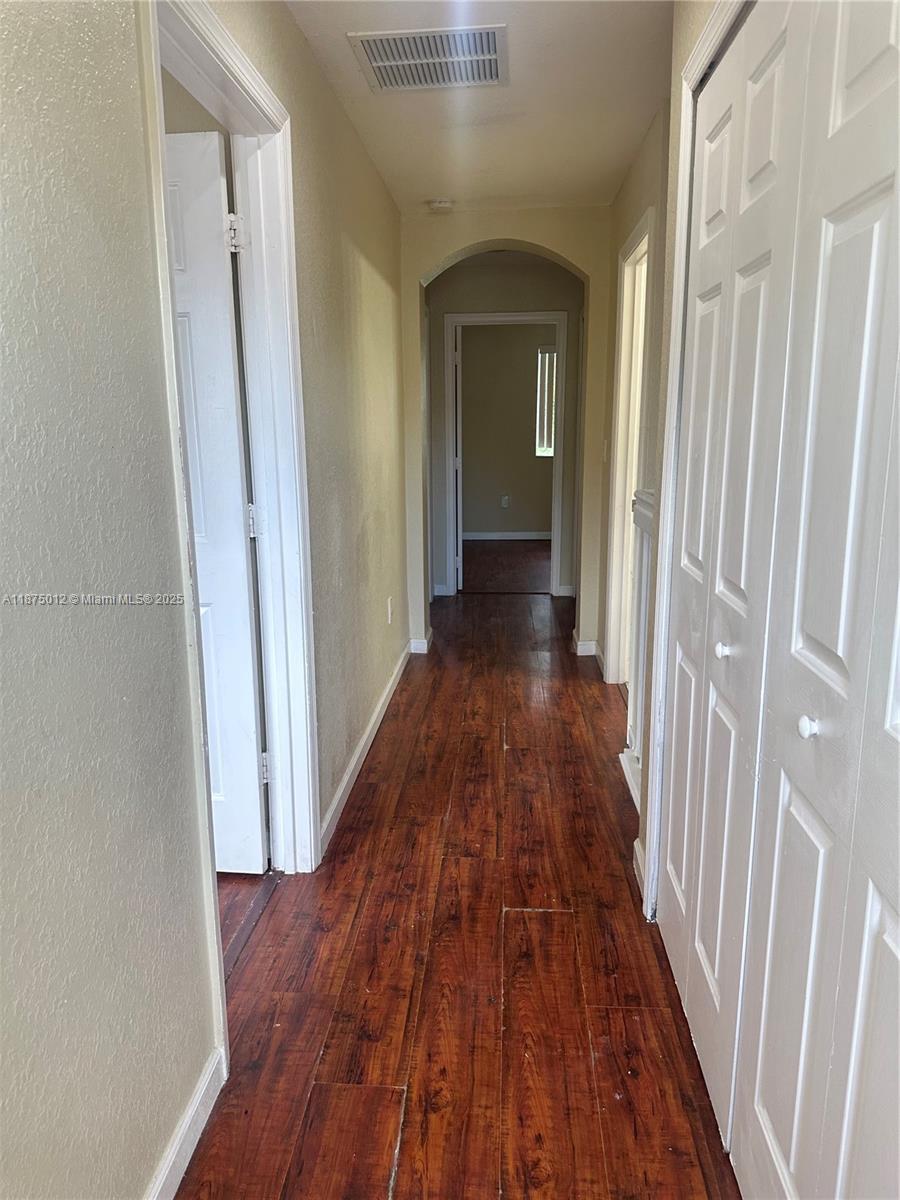 2834 Southeast 16th Avenue, Unit 111 Homestead, FL 33035 - Photo 15 of 22 a view of a hallway with wooden floor and a bathroom