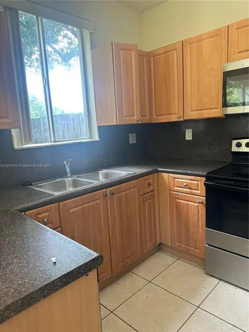 a kitchen with stainless steel appliances a refrigerator sink and cabinets