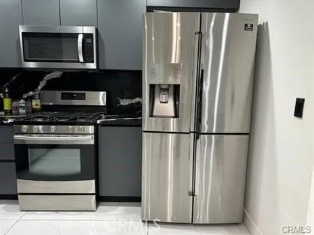 a kitchen with stainless steel appliances a refrigerator a stove a microwave and cabinets