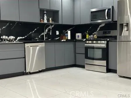 a kitchen with stainless steel appliances granite countertop a stove and a microwave