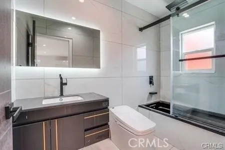 a bathroom with a sink a toilet a mirror and shower