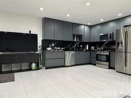 a kitchen with stainless steel appliances granite countertop a refrigerator and a stove