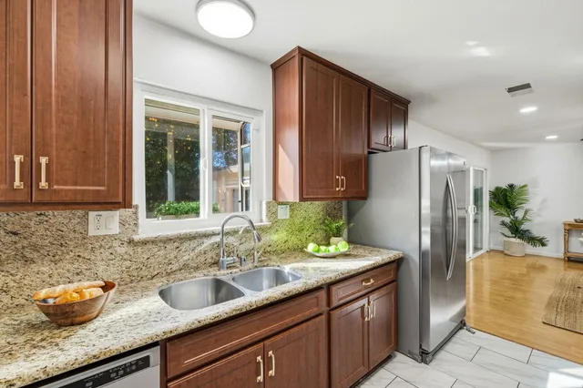 a kitchen with stainless steel appliances granite countertop a refrigerator and a sink