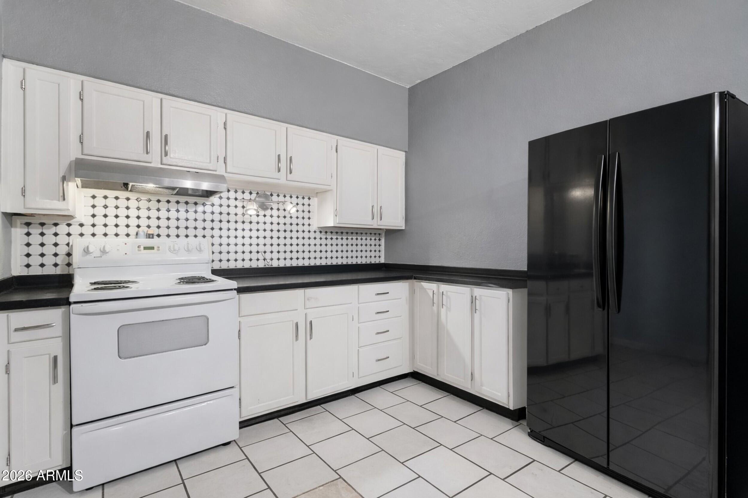 355 East Thomas Road, Unit B208 Phoenix, AZ 85004 - Photo 3 of 22 a kitchen with white cabinets and white appliances
