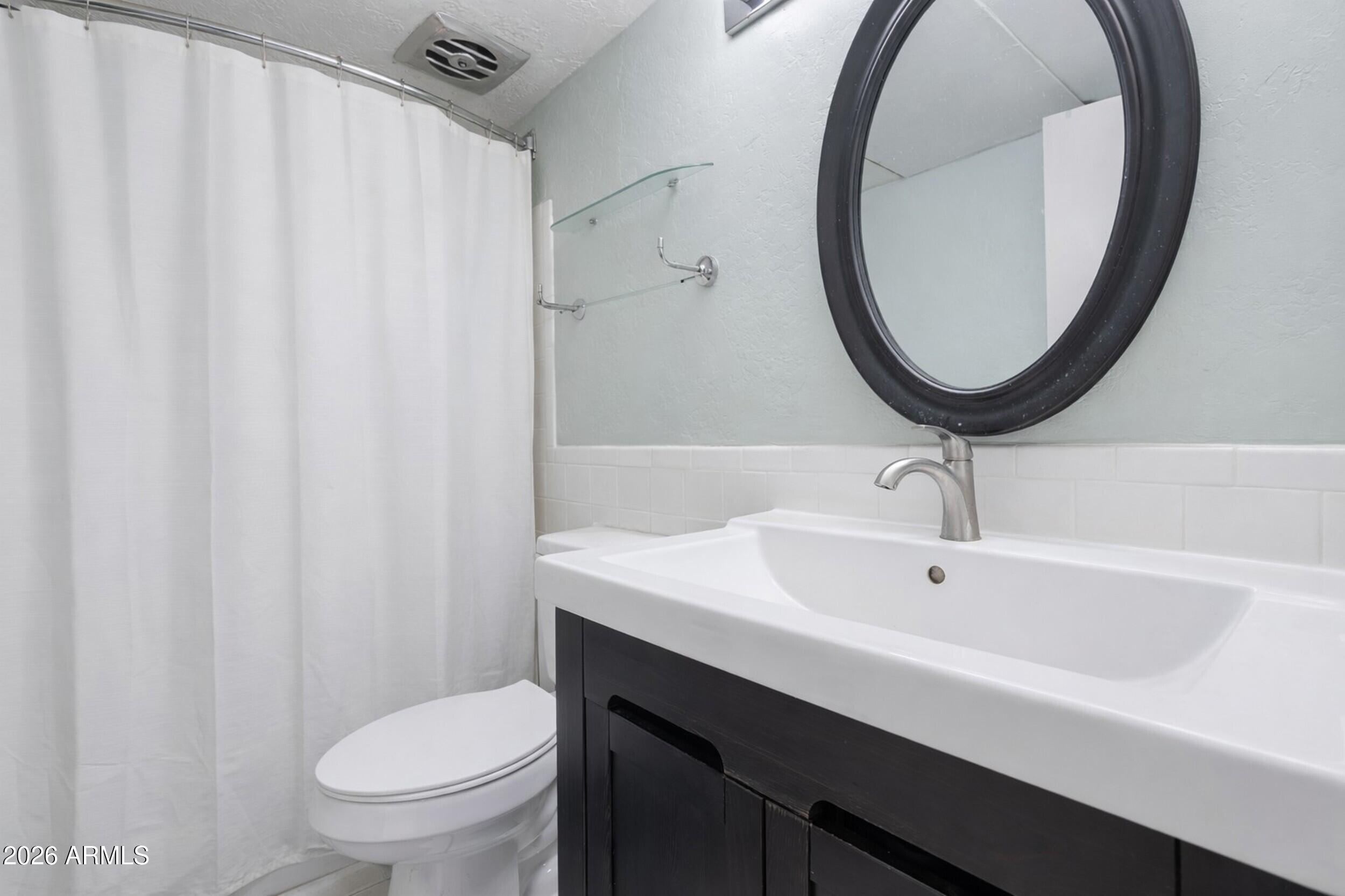 355 East Thomas Road, Unit B208 Phoenix, AZ 85004 - Photo 9 of 22 a bathroom with a sink a toilet and a mirror