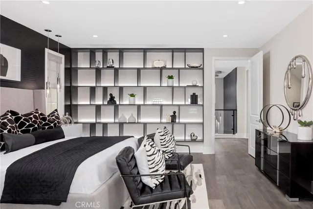 a bedroom with a bed a dresser and a chandelier