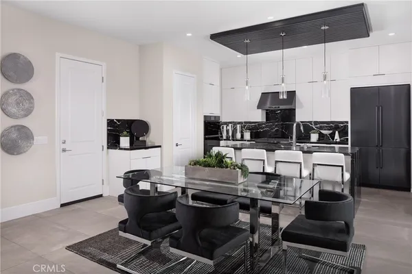 a kitchen with stainless steel appliances kitchen island granite countertop a stove a sink a refrigerator and white cabinets