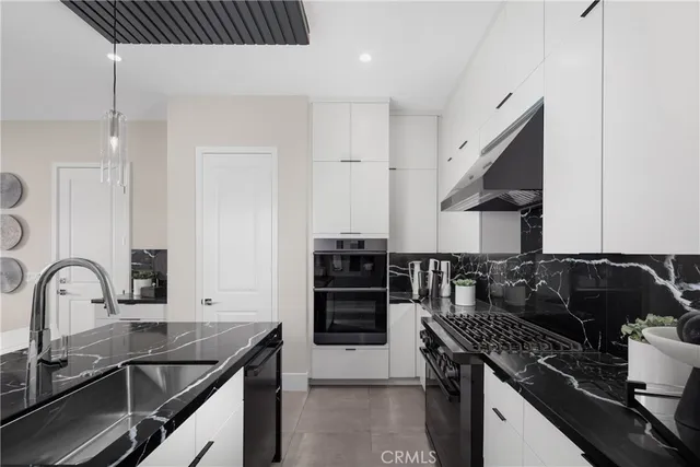 a kitchen with granite countertop a stove and a sink