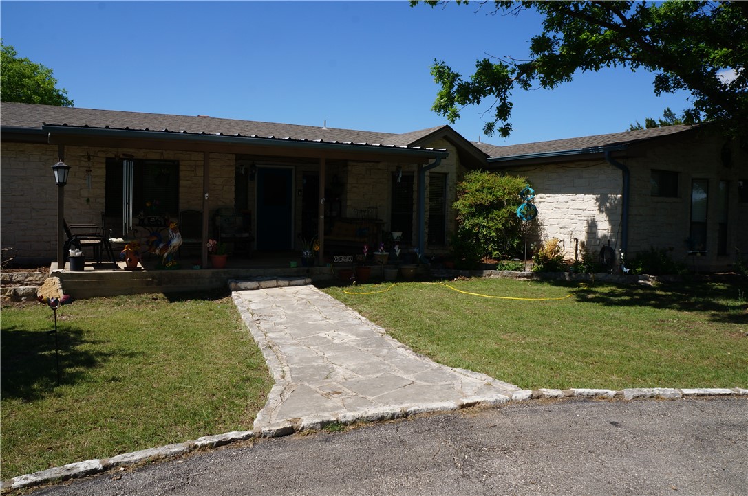 a front view of a house with a yard and potted plants